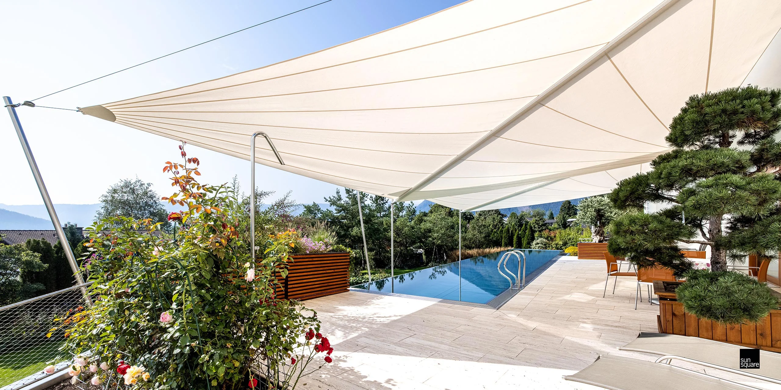 Modernes weißes Sonnensegel Fürstenfeldbruck über einer Pool-Terrasse.