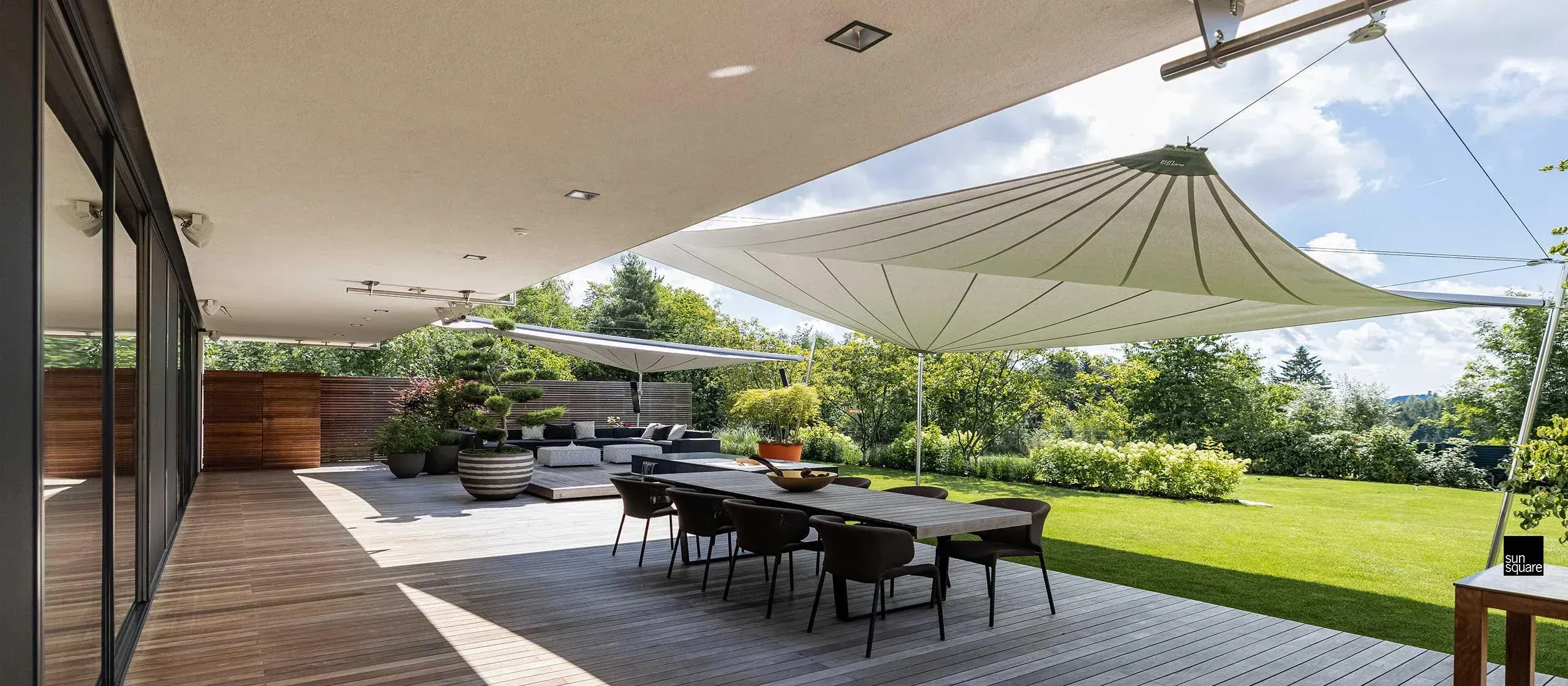 Überdachte Terrasse mit Sitzbereich und Sonnensegel