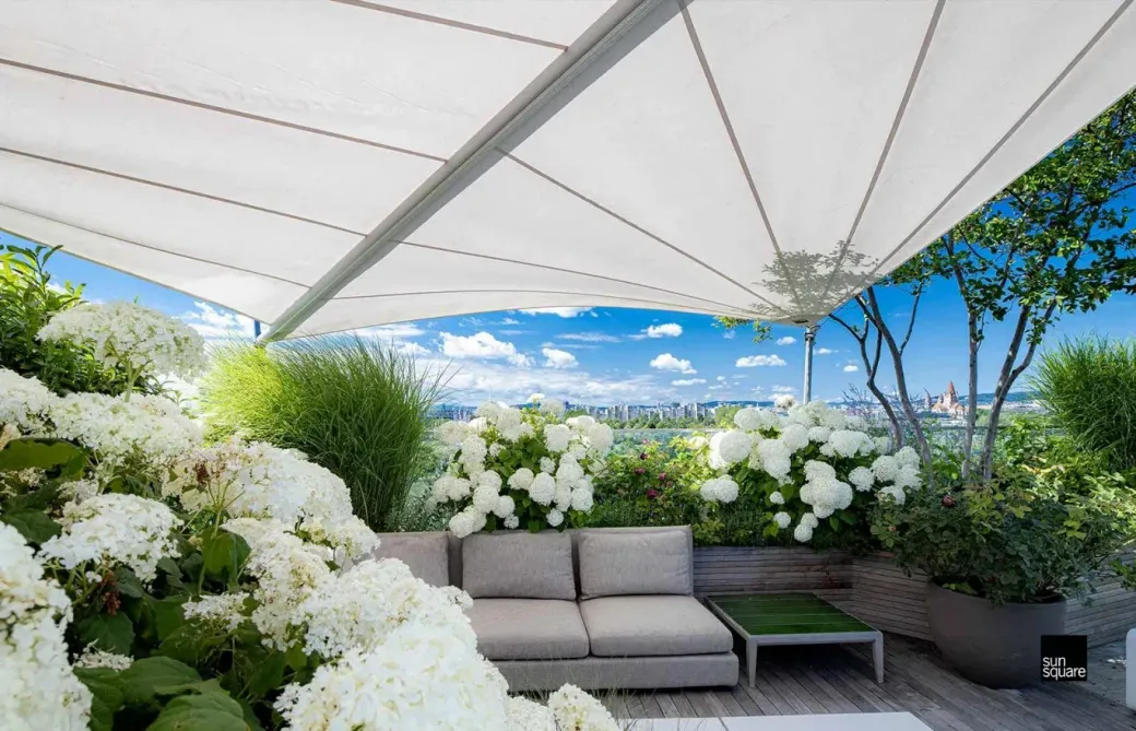 Sitzecke mit weißen Blüten und Markise